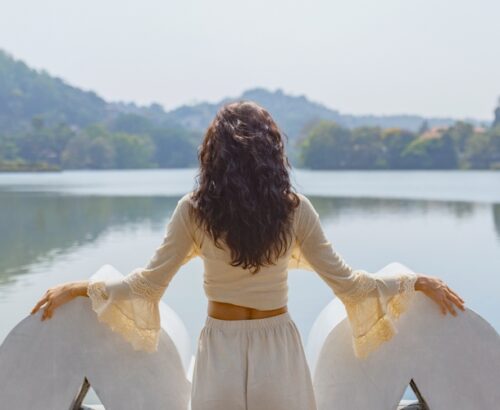 A,Woman,In,A,White,Dress,Stands,By,The,Lake